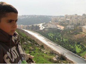 Gibreel, son of filmmaker Emad Burnat, looks at the new housing that's been built since he was born.