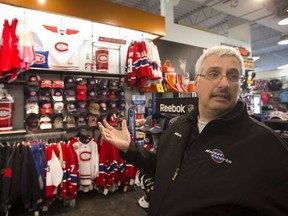 Hockey Experts assistant manager Keith Murray shows some of the licensed NHL gear in his Dollard store.