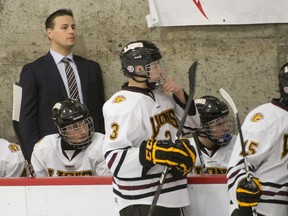 Chris Lyness assists behind the midget AAA Lions bench.