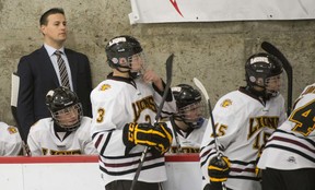 Chris Lyness assists behind the midget AAA Lions bench.