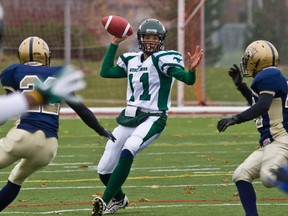 North Shore Mustangs quarterback Jason McInnis looks down field to receiver Hergy Mayala, left, during QMFL playoff loss to the Laurentian Wildcats on Sunday.