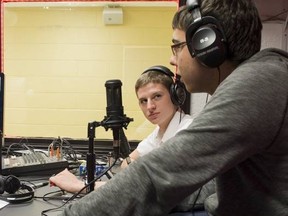 Teacher Louis Bilodeau, left, and student Micah Watts, centre, chat with former student Paris Tsovrasin at the Lauren Hill radio station.