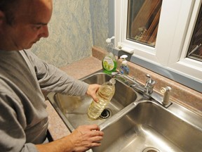 Yves Simard shows the yellow tint to water coming from his sink.