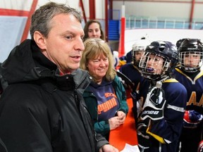 Marc Travers talks to his players on the Queen of Angels team between periods.