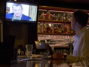 A photo illustration shows a man watching a TV showing disgraced cycling star Lance Armstrong with Oprah Winfrey is seen in a bar in downtown Los Angeles January 17. 2013.  During the interview Lance Armstrong admited doping while competing professionally in the sport.. AFP PHOTO / Robyn BeckROBYN BECK/AFP/Getty Images