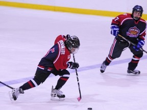 Kylian Descaillot of the West Island Royals (blue) skates through centre ice to lead an attack.