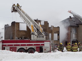 Fire fighters examine all that's left of a Riviere des Prairies home that was gutted by an explosion Thursday morning. (Pierre Obendrauf / THE GAZETTE)