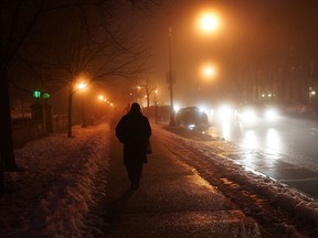 NEW YORK, NY - FEBRUARY 11: A woman  walks down a Brooklyn street shrouded in fog on February 11, 2013 in New York City. Following a massive snowstorm that left up to three feet of snow in some parts of New England, Monday saw warm temperatures and light rain which resulted in dense fog in many areas. All New York City airports experienced delays due to the fog.  (Photo by Spencer Platt/Getty Images)