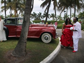 Newlyweds  Rem David (L) and Jenny Briceno (2nd L) and Karean Butler (2nd R) and Karlo Butler walk near a Rolls-Royce after taking part in a group Valentine's day wedding at the National Croquet Center on February 14, 2013 in West Palm Beach, Florida. The group wedding ceremony is put on by the Palm Beach Country Clerk & Comptroller's office and approximately 40 couples to tied the knot.  (Photo by Joe Raedle/Getty Images)