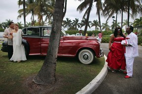 Newlyweds  Rem David (L) and Jenny Briceno (2nd L) and Karean Butler (2nd R) and Karlo Butler walk near a Rolls-Royce after taking part in a group Valentine's day wedding at the National Croquet Center on February 14, 2013 in West Palm Beach, Florida. The group wedding ceremony is put on by the Palm Beach Country Clerk & Comptroller's office and approximately 40 couples to tied the knot.  (Photo by Joe Raedle/Getty Images)