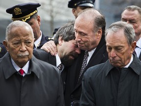 NEW YORK, NY - FEBRUARY 26:  Former New York City Mayor David Dinkins, left, and current New York City Mayor Michael Bloomberg, right, attend the 20th Anniversary Ceremony for the 1993 World Trade Center bombing at Ground Zero while Stephen Knapp, son of a victim of the attack, cries on the shoulder of Charles Maikish, former director of the World Trade Department, on February 26, 2013 in New York City. The attack, which utilized a car bomb and hit the north tower, killed six people.  (Photo by Andrew Burton/Getty Images) ORG XMIT: 162741884