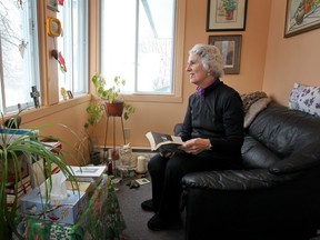 Eleanor Arless looks through her mother's bible in the prayer corner of her home in Pointe Claire.