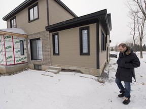 Chiotis walks by the extension, at right, that was completed without a permit. He has since started a second extension, at left.