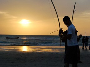 A man prepares to play berimbau, the African bow used in capoeira, at dusk on the beach in Jericoacoara, in the state of Ceara in Brazil.