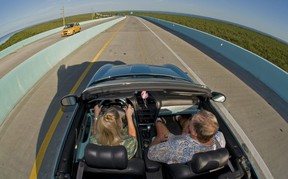 A couple rides in a convertible car, Wednesday, Sept. 28, 2011, near Key Largo, Fla., Canadians visiting Florida were surprised to hear they now need an International Driving Permit to motor around the state. But  Florida officials have now said that enforcement of the rule would be deferred. THE CANADIAN PRESS/AP-Florida Keys News Bureau, Andy Newman