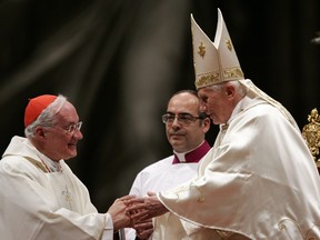 Pope Benedict XVI (right) greets Cardinal Marc Ouellet, of Canada, at the beginning of a mass in St. Peter's Basilica at the Vatican, in 2011.  Pope Benedict XVI's announcement today he would leave the papacy has left bookmakers touting  Ouellet as a favourite to succeed the pontiff.(AP Photo/Riccardo De Luca)