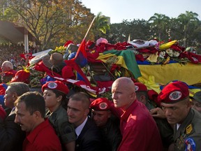 Venezuelans accompany the funeral cortege of late Venezuelan President Hugo Chavez on its way to the Military Academy, on March 6, 2013, in Caracas. The flag-draped coffin of Venezuelan leader Hugo Chavez was borne through throngs of weeping supporters on Wednesday as a nation bade farewell to the firebrand leftist who led them for 14 years. EITAN ABRAMOVICH/AFP/Getty Images