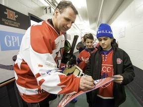 Gaston Gingras signs an autograph after a game at the Hockey Helps the Homeless fundraiser at Sportsplexe 4 Glaces in Pierrefonds on March 22.