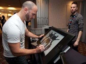 Artist Joel Viegas draws a video game character at the Wacom booth during last year's Montreal International Games Summit. Wacom rep Jerome Abramovitch is pictured at right.(Allen McInnis/THE GAZETTE)