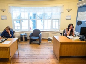 Human Relations Agents Monique Caissie, left, and Sophie Magnan, right, speak to clients on the phone at the West Island Crisis Centre in Pierrefonds.