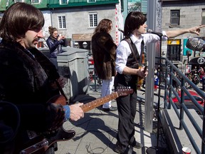 MONTREAL, QUE: MARCH 26, 2013-- Members of the Beatles tribute rock group, Day Tripper - The Beatles Experience, perform on St-Denis street on Tuesday March 26, 2013.The group includes Danny Di Donato playing Paul McCartney, right, Peter Grant playing John Lennon, centre and Jeremy Di Donato playing George Harrison.   (Pierre Obendrauf / THE GAZETTE) ORG XMIT: 46298-055