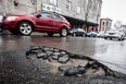 Cars drive past a large pothole on St. Laurent Blvd. near the corner of Sherbrooke St. As Montreal streets begin their annual, springtime  deterioration, a deadlock at city hall has left the city with no asphalt for repairs. (Dario Ayala / THE GAZETTE)