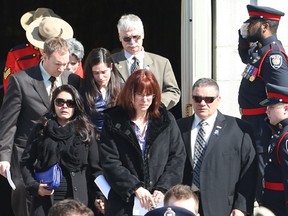 Gilles (right) and Celine Dery (centre), the parents of slain Kativik Regional police officer Steve Dery, and Steve Dery's partner Amanda Tukirqi (left) leave his funeral at Notre-Dame Basilica in Ottawa on Saturday, March 9, 2013. THE CANADIAN PRESS/ Patrick Doyle ORG XMIT: PD106