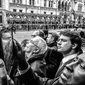 A man photographs using a tablet asp5 as people look on as the funeral cortege of former British Prime Minister Baroness Thatcher passes by the Royal Courts of Justice on April 17, 2013 in London, England. Dignitaries from around the world today join Queen Elizabeth II and the Prince Philip, Duke of Edinburgh as the United Kingdom pays tribute to former Prime Minster Baroness Thatcher with a Ceremonial funeral with military honours at St Paul's Cathedral. Lady Thatcher, who died last week, was the first British female Prime Minister and served from 1979 to 1990.