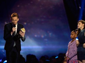 Actor Tom Hiddleston says thank you for the Best Villain award for Marvel's The Avengers while Quvenzhane Wallis and Chloe Grace Moretz watch, at the 2013 MTV Movie Awards on April 14, 2013 in Culver City, California.  (Photo by Kevork Djansezian/Getty Images)