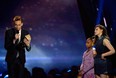 Actor Tom Hiddleston says thank you for the Best Villain award for Marvel's The Avengers while Quvenzhane Wallis and Chloe Grace Moretz watch, at the 2013 MTV Movie Awards on April 14, 2013 in Culver City, California.  (Photo by Kevork Djansezian/Getty Images)