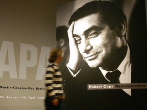 BERLIN, GERMANY:  A woman walks past a poster showing a portrait of Hungarian-French war photographer Robert Capa, 21 January 2005 at the Martin-Gropius-Bau in Berlin.  (JOHANNES EISELE/AFP/Getty Images)