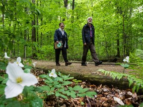 David Fletcher and Sylvia Oljemark walk through woods of  Bois de Liesse park, an area they help save from development.
