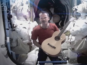 Canadian Astronaut and ISS commander Chris Hadfield is framed by spacesuits as he performs David Bowie's Space Oddity on the International Space Station, in a video published on YouTube on Sunday. Hadfield has won praise for re-igniting the public's interest in space exploration and science. But just how good a salesman was the spaceman? THE CANADIAN PRESS/HO, CSA - Chris Hadfield