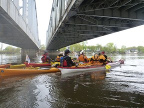 Kayakers participating in June 2012 Tour de l'ile bleu pass beneath the Lachapelle Bridge spanning Riviere des Prairies.