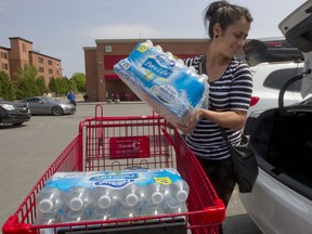 Marie Jose Vieira with bottled water that she purchased for a daycare in Montreal. The city issued a boil water advisory for areas around the island, including downtown, after it was discovered that water at a treatment plant was contaminated with sediment from renovations.  ( Phil Carpenter THE GAZETTE  )