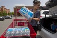 Marie Jose Vieira with bottled water that she purchased for a daycare in Montreal. The city issued a boil water advisory for areas around the island, including downtown, after it was discovered that water at a treatment plant was contaminated with sediment from renovations.  ( Phil Carpenter THE GAZETTE  )