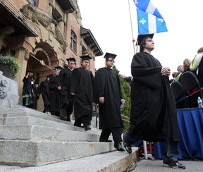 Graduates proceed out of the Hertzberg Building to the lawn.