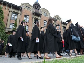 Graduates proceed out of the Hertzberg Building to the lawn.