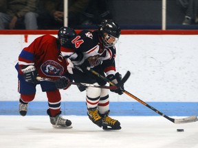 Hunter Moreau keeps puck away from opposing player.