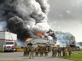 Firefighters gather at the scene of an explosion at the B.E.M. fireworks factory Thursday, June 20, 2013 in Coteau-du-Lac, Que. Two people were killed in a massive explosion at a fireworks warehouse that rattled homes and sent up a cloud of smoke that could be seen for kilometres outside Montreal THE CANADIAN PRESS/Stephane Brunet