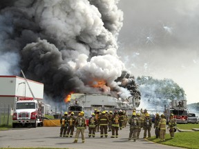 Firefighters gather at the scene of an explosion at the B.E.M. fireworks factory on June 20.
