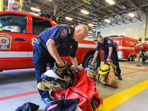 Vaudreuil-Dorion firefighters Lt. Terry Sonnel, left and Yann Blais prepare their equipment for the trip to Lac-Mégantic.