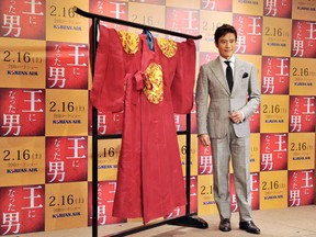 Actor Lee Byung-Hun poses next to a costume  from the film Masquerade. He plays a king and his  doppelganger in the film. (KAZUHIRO NOGI/AFP/Getty Images)