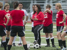 Cathy Lipari, pictured with foot resting on ball, has been coaching soccer since she was 16 years old. (Graham Hughes/THE GAZETTE)