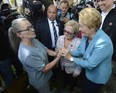 Quebec Premier Pauline Marois (right) holds hands with resident Francoise Roy as Lac-Megantic, Que. mayor Colette Roy-Laroche looks on, as they make their way to a news conference in Lac-Megantic, Que. on Thursday July 11, 2013. THE CANADIAN PRESS/Ryan Remiorz