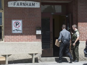 Officers from the Surete du Quebec enter the premises of Montreal Maine & Atlantic railway offices in Farnham, Que., Thursday, July 25, 2013. A train belonging fo MMA carrying crude oil derailed on July 6 last and exploded in the town of Lac Megantic resulting in the loss of almost 50 lives. Graham Hughes/THE GAZETTE)