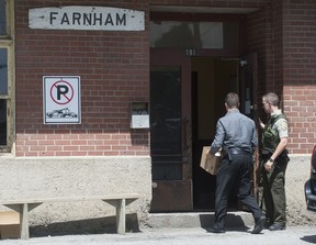 Officers from the Surete du Quebec enter the premises of Montreal Maine & Atlantic railway offices in Farnham, Que., Thursday, July 25, 2013. A train belonging fo MMA carrying crude oil derailed on July 6 last and exploded in the town of Lac Megantic resulting in the loss of almost 50 lives. Graham Hughes/THE GAZETTE)