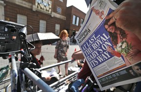 A news cameraman reads a newspaper across St. Mary's Hospital exclusive Lindo Wing in London, Monday, July 22, 2013. Prince William's wife, Kate Middleton, the Duchess of Cambridge, gave birth to an eight pound, six ounce baby boy at 4:24 p.m. London time. The happy news delays if not necessarily dispenses with a possibly divisive debate within the Commonwealth over the rules of royal succession had the third heir to the throne been a girl.  (AP Photo/Lefteris Pitarakis)
