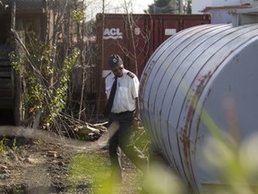 A security guard surveys containers in yard at Reliance Power Equipment in Pointe-Claire on Aug. 29, 2013.