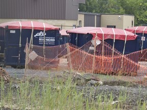 Covered containers in a compound beside Reliance building on Hymus Blvd.